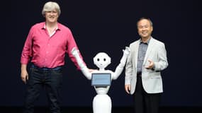 Le robot Pepper, entouré des présidents d'Aldebaran et de Softbank.
