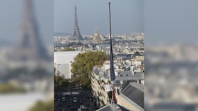 Un militant écologiste s’accroche au drapeau du Panthéon à Paris.