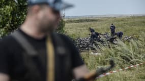 Un séparatiste pro-russe monte la garde devant des débris de l'avion de la Malaysia Airlines, près du village de Grabove, dans l'est de l'Ukraine, le 20 juillet 2014.