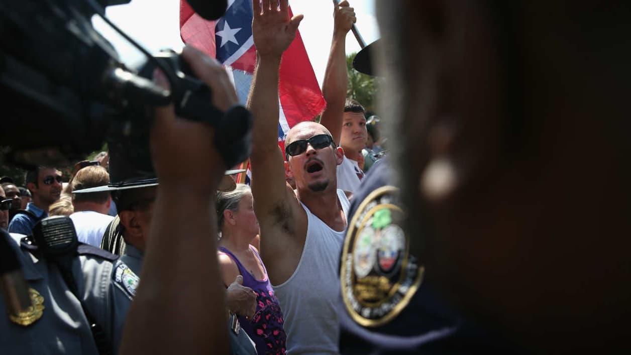Un membre du Klan faisant le salut nazi, le 18 juillet 2015, à Columbia (Caroline du Sud). Un membre du Klan faisant le salut nazi, le 18 juillet 2015, à Columbia (Caroline du Sud).