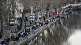 Des Parisiens flânant au bord du canal Saint-Martin le dimanche 15 mars 2020, malgré la propagation du coronavirus
