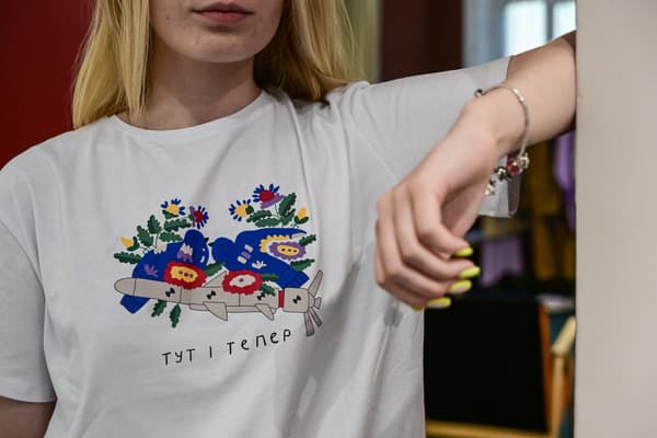 Anna Perebynos, 22 ans, pose avec un tee-shirt de la marque Balcony Garment inspiré du conflit en Ukraine, à Kiev, le 2 juillet 2022 Anna Perebynos, 22 ans, pose avec un tee-shirt de la marque Balcony Garment inspiré du conflit en Ukraine, à Kiev, le 2 juillet 2022