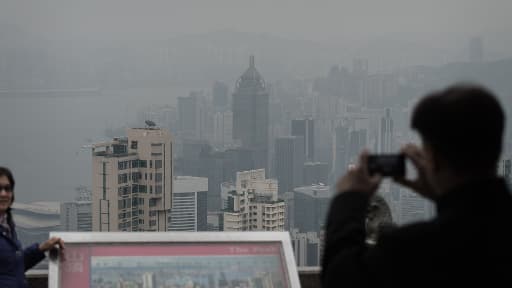 Des touristes immortalisent le nuage de pollution permanent qui flotte au-dessus de Hong Kong.