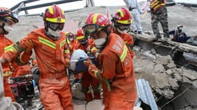 Les sauveteurs chinois sortant un blessé des décombres, le 8 mars 2020