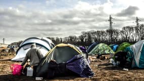 Un migrant devant une tente dans un campement informel, près du port de Calais, le 18 février 2019