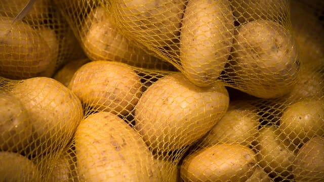 Des pommes de terre emballées dans un filet. (image d'illustration)