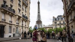 Un groupe de touristes pose devant la tour Eiffel à Paris le 4 mai 2024.