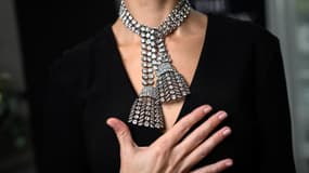 Une femme pose avec un collier de diamants du 18e siècle pesant environ 300 carats, lors d'une présentation à la presse à la maison de vente aux enchères Sotheby's à Genève, le 7 novembre 2024.