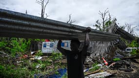 Un homme récupère une tôle pour reconstruire sa maison endommagée par le cyclone Chido à Mayotte le 4 janvier 2025