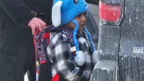 Cette photo obtenue le 23 janvier 2026 montre un agent de l'ICE tenant le sac à dos de Liam Conejo Ramos, 5 ans, alors qu'il est arrêté le 20 janvier 2026 à Minneapolis, dans le Minnesota.