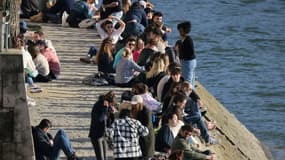 Des personnes se rassemblent le long de la Seine pour profiter d'un après-midi ensoleillé, à Paris, le 28 février 2021