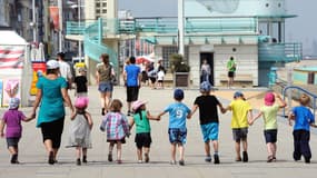 Un moniteur de colonie de vacances s'occupe d'enfants le 25 juillet 2013 à la plage de Malo-les-Bains, dans le nord de la France.