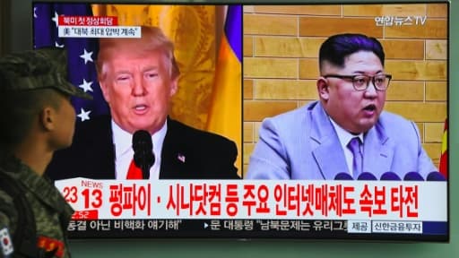 Un soldat sud-coréen regarde les portraits de Donald Trump et Kim Jong Un à la télévision, le 9 mars 2018