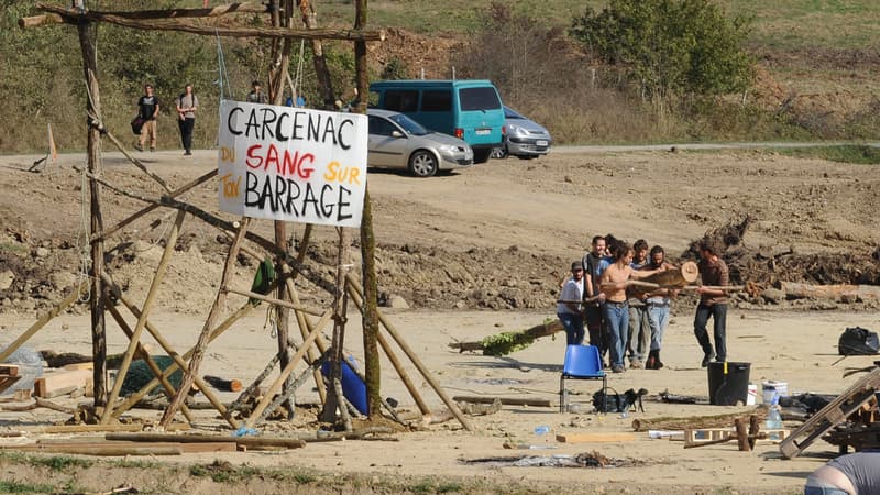Des opposants au barrage de Sivens près de leurs barricades avec sur une pancarte la mention: "Carcenac (nom du président du conseil général du Tarn), il y a du sang sur ton barrage".
