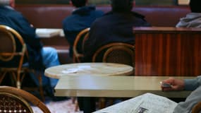 Des personnes regardent les résultats des courses, le 20 octobre 2008 dans un café à Paris.