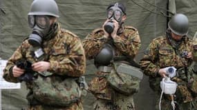 Des soldats japonais se préparent pour des opérations de décontamination nucléaire à Nihonmatsu, dans le secteur de la centrale de Fukushima, où le niveau de radioactivité grimpe après deux nouvelles explosions et un incendie mardi. /Photo prise le 15 mar