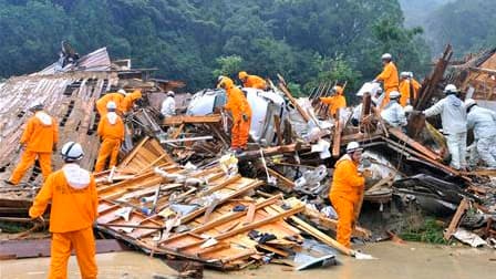 Pompiers à l'oeuvre au milieu des décombres de maisons après un glissement de terrain consécutif aux précipitations liées au passage de la dépression Talas à Tanabe, dans l'ouest du Japon. Cette dépression, précédemment classée comme une tempête tropicale