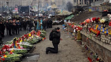 Un homme pleure devant un mémorial commémorant les manifestants tués pendant les violences en Ukraine, le 23 février 2014.
