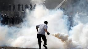 Affrontements entre manifestants et policiers anti-émeutes au Caire, dimanche. Le président égyptien Mohamed Morsi a fait dimanche un geste en direction de ses adversaires en se disant prêt à dialoguer avec "l'ensemble des forces politiques" et en soulign