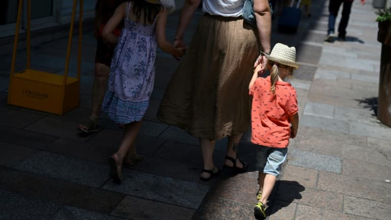 Des piétons recherchent l'ombre dans une rue d'Avignon, le 17 juillet 2023 dans le Vaucluse