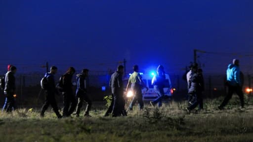 Des migrants marchent dans la nuit à Coquelles, dans le Pas-de-Calais, en août 2015 - image d'illustration