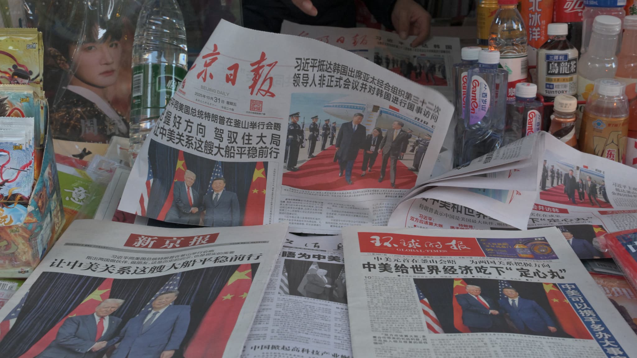 Ένας πωλητής παρουσιάζει εφημερίδες των οποίων τα πρωτοσέλιδα εμφανίζουν τη συνάντηση μεταξύ του προέδρου των ΗΠΑ Ντόναλντ Τραμπ και του Κινέζου Προέδρου Σι Τζινπίνγκ στη Νότια Κορέα, σε περίπτερο στο Πεκίνο, 31 Οκτωβρίου 2025