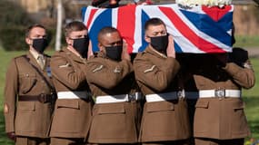 Le cercueil de Tom Moore, enveloppé du drapeau britannique, a été porté sous un soleil printanier par six soldats d'infanterie jusqu'au crématorium de Bedford.