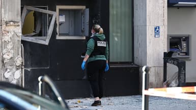 Une membre de la police scientifique inspecte la façade d'un bureau de poste à Roubaix après un braquage à l'explosif, le 12 novembre 2025.