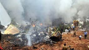 Pompiers à l'oeuvre après l'accident d'un avion de la compagnie Air India Express à Mangalore, dans le sud de l'Inde. Seules huit personnes parmi les 166 passagers et membres d'équipage qui étaient présents à bord ont survécu. /Photo prise le 22 mai 2010/