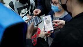 Un salarié de la SNCF contrôle le pass sanitaire d'un passager sur son téléphone portable à la gare de Lyon à Paris, le 9 août 2021