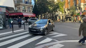 Une voiture s'engage dans la rue Orfila (Paris 20e arrondissement)