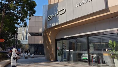 Des personnes se tiennent devant un atelier automobile du fabricant chinois de véhicules électriques BYD Co. Ltd. à Shanghai, dans l'est de la Chine, le 27 décembre 2024. Un sous-traitant du géant chinois des véhicules électriques BYD a nié le 26 décembre l'existence de "conditions proches de l'esclavage" dans une usine brésilienne, où les responsables locaux ont déclaré avoir trouvé des preuves de travail forcé.