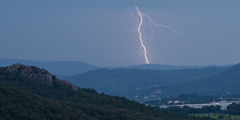 Un éclair frappe une colline au loin lors d'un orage près du Muy, dans le sud de la France, le 12 juin 2023.