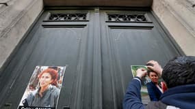 Un homme affiche des portraits des militantes kurdes assassinées dans la nuit du 9 au 10 janvier au Centre d'information du Kurdistan, à Paris.