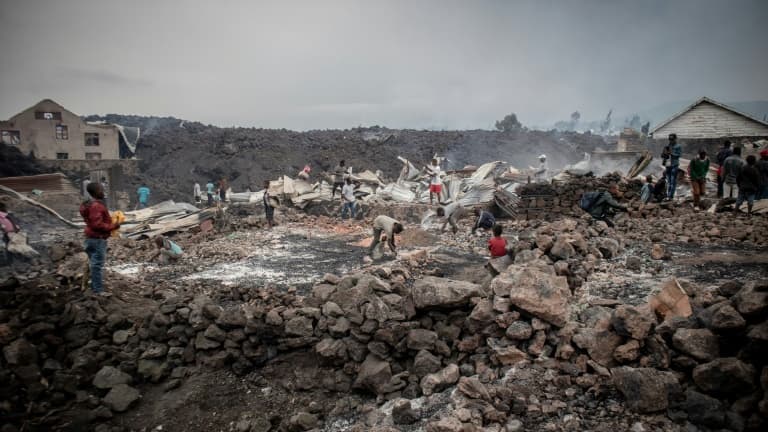 Des habitants de Goma découvrent les dégâts provoqués par une coulée de lave du volcan Nyiragongo, le 23 mai 2021 en RDC