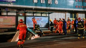Les services de secours chinois préparent la remontée du bus tombé dans un trou formé soudainement sur la chaussée, à Xining, en Chine, le 13 janvier 2020