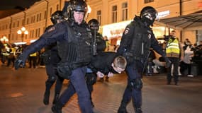 Des policiers détiennent un homme à Moscou le 21 septembre 2022, suite aux appels à protester contre la mobilisation partielle annoncée par le président Vladimir Poutine.