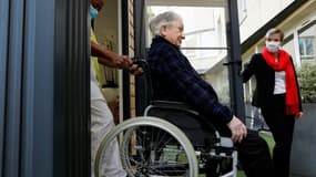 Une soignante aide Guy, 93 ans, à entrer dans un mobile-home où il va pouvoir déjeuner avec ses filles, le 12 novembre 2020 à l'Ehpad Beauregard de Villeneuve-Saint-Georges, près de Paris