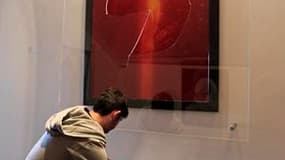 Un employé de la Collection Lambert ramasse le verre brisé du "Piss Christ", oeuvre du photographe américain Andres Serrano, vandalisée dimanche à Avignon. La Collection Lambert prévoit de rouvrir le musée d'Avignon aux visiteurs mardi, et dit avoir reçu