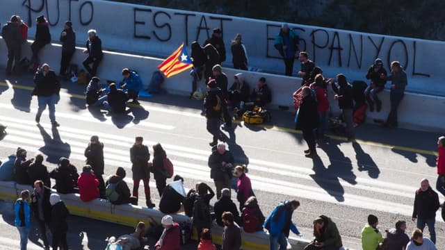 Un homme tient un drapeau de la Catalogne alors que des manifestants bloquent l'autoroute A9 à la frontière entre la France et l'Espagne, le 11 novembre 2019