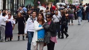 des gens se réconfortent les uns les autres dans la rue, après le puissant séisme ressenti jeudi, dans le sud ouest du Mexique.