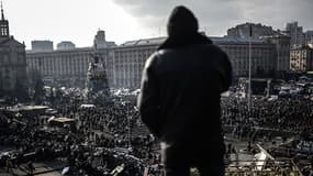 Des Ukrainiens se réunissent sur la place de l’Indépendance qui porte encore les traces des combats de la veille.