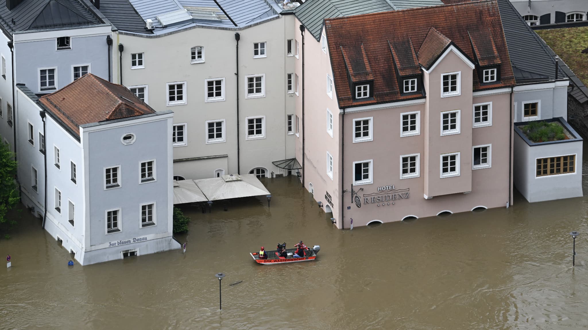 Un bateau avec des sauveteurs naviguent à travers une rue et des bâtiments inondés dans le centre de Passau en Bavière, dans le sud de l'Allemagne, le 4 juin 2024.