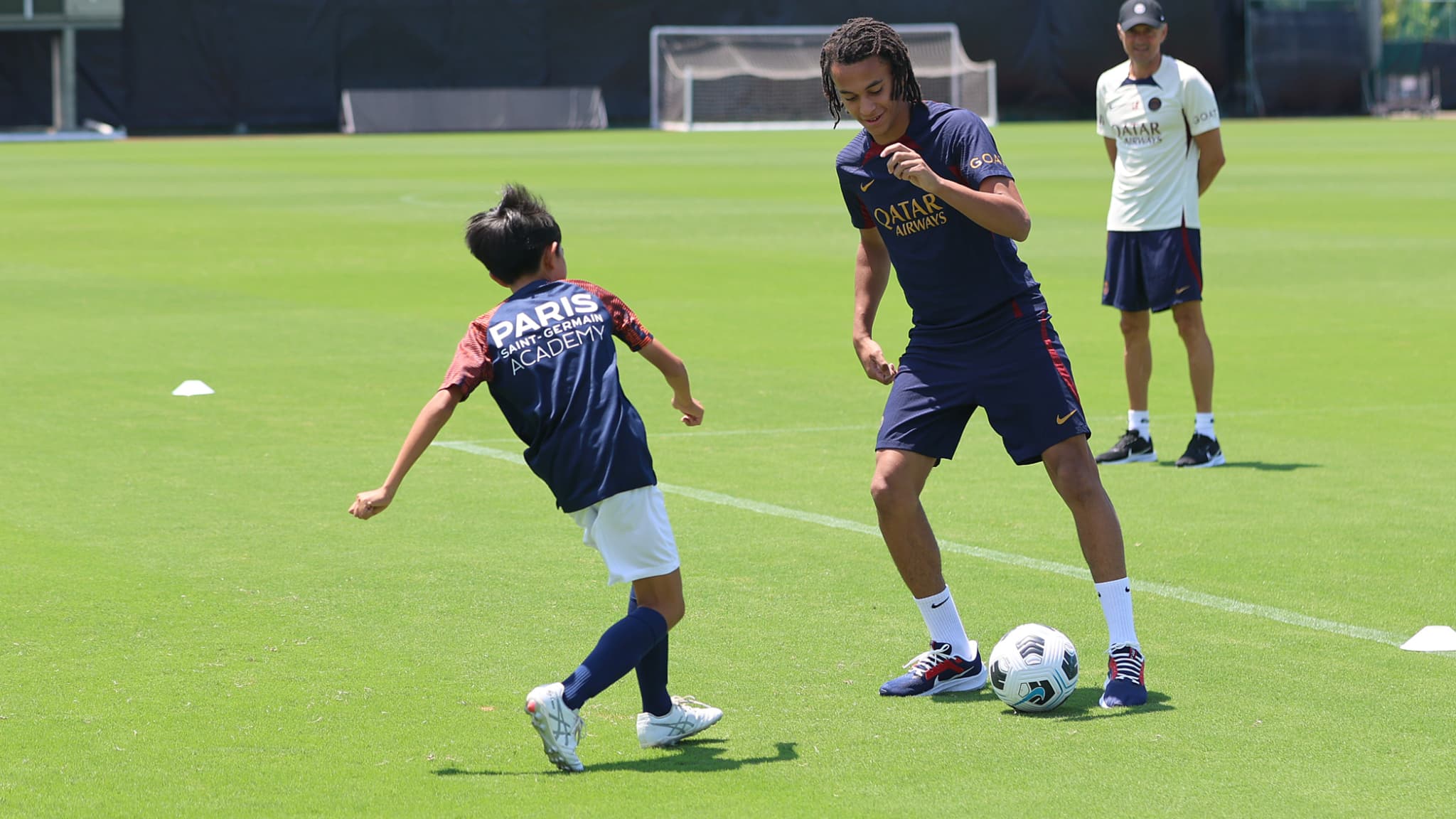 Ethan Mbappé avec un jeune Japonais pendant la tournée du PSG au Japon, le 24 juillet 2023