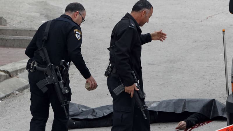 Deux policiers israéliens entourant le corps d'un palestinien, le