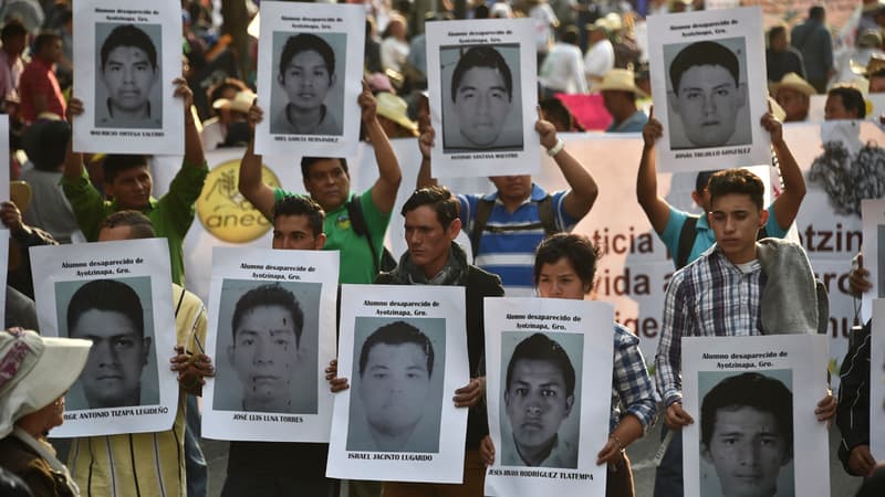 Des familles portent les portraits d'étudiants disparus fin septembre au Mexique.