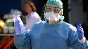 Une infirmière anesthésiste, lors de la désinfection d'une ambulance qui a transporté six malades du Covid-19 évacués vers l'hôpital de Brest, le 24 mars 2020. (Illustration.)