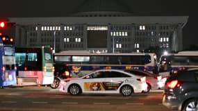 Des véhicules de police devant l'Assemblée nationale à Séoul le 4 décembre 2024.