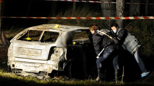 Des enquêteurs de la police judiciaire aux premières investigations sur un véhicule calciné où trois corps ont été retrouvés, le 26 décembre 2011 aux Pennes-Mirabeau.
