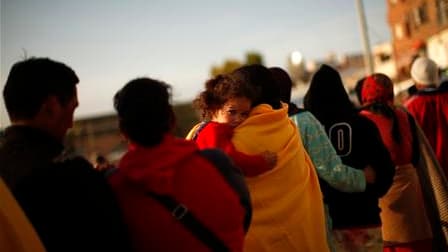 Queue pour obtenir des vivres à Lorca, dans le sud-est de l'Espagne. Les secouristes ont interdit de regagner pour l'instant les habitations, endommagées par un séisme qui a fait huit morts mercredi. /Photo prise le 12 mai 2011/REUTERS/Jon Nazca